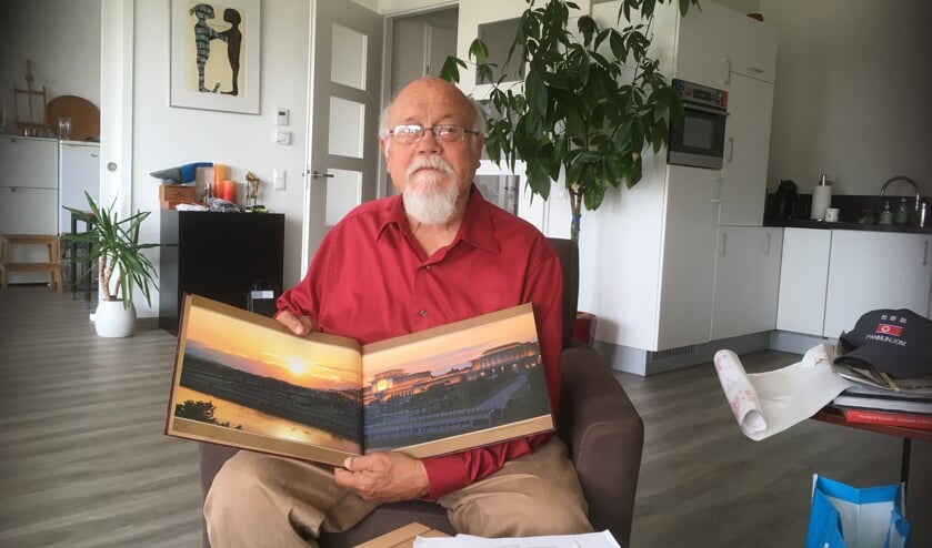 Boll Thomson thuis met een fotoboek over Noord-Korea. | Foto: CvdS