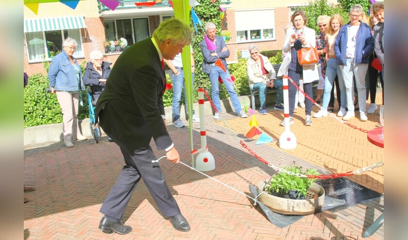 Wethouder Kees van der Zwet onthult de buurtprijs in de vorm van een tegel.