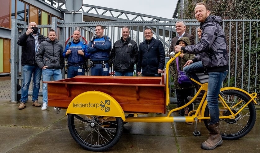 Ron Sanders op zijn gloednieuwe bakfiets met achter de fiets wethouder Daan Binnendijk en Ron's supporters.