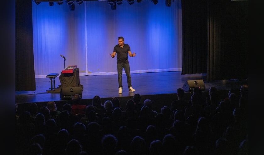 Rayen Panday heeft de lachers op zijn hand in een volle toneelzaal. | Foto en tekst: Remco Out.