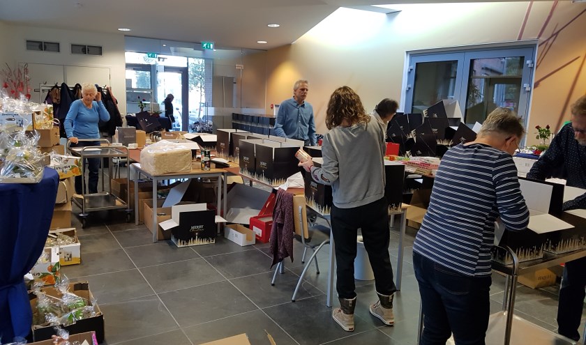 Vrijwilligers werken hard om alle kerstpakketten klaar te maken. | Foto: PR