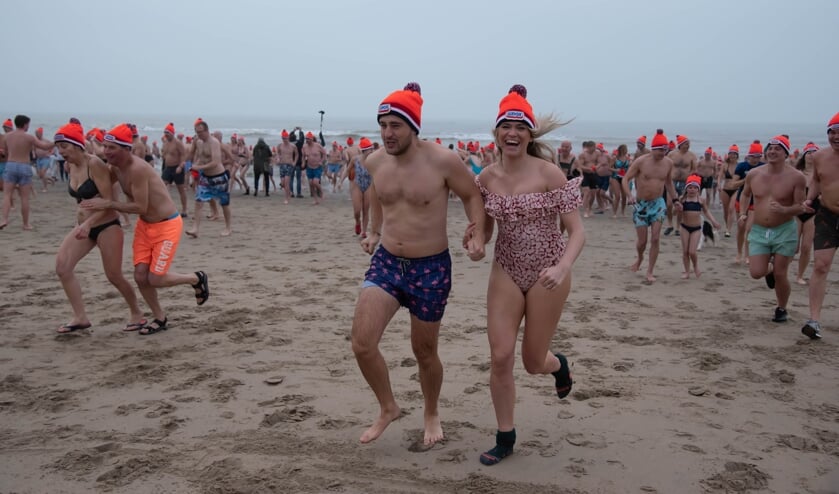 Lachend uit de koude zee rennen: zouden het de sokken zijn? Deze dame heeft er ondanks de kou nog zichtbaar lol in. | Foto: Richard van Egmond.
