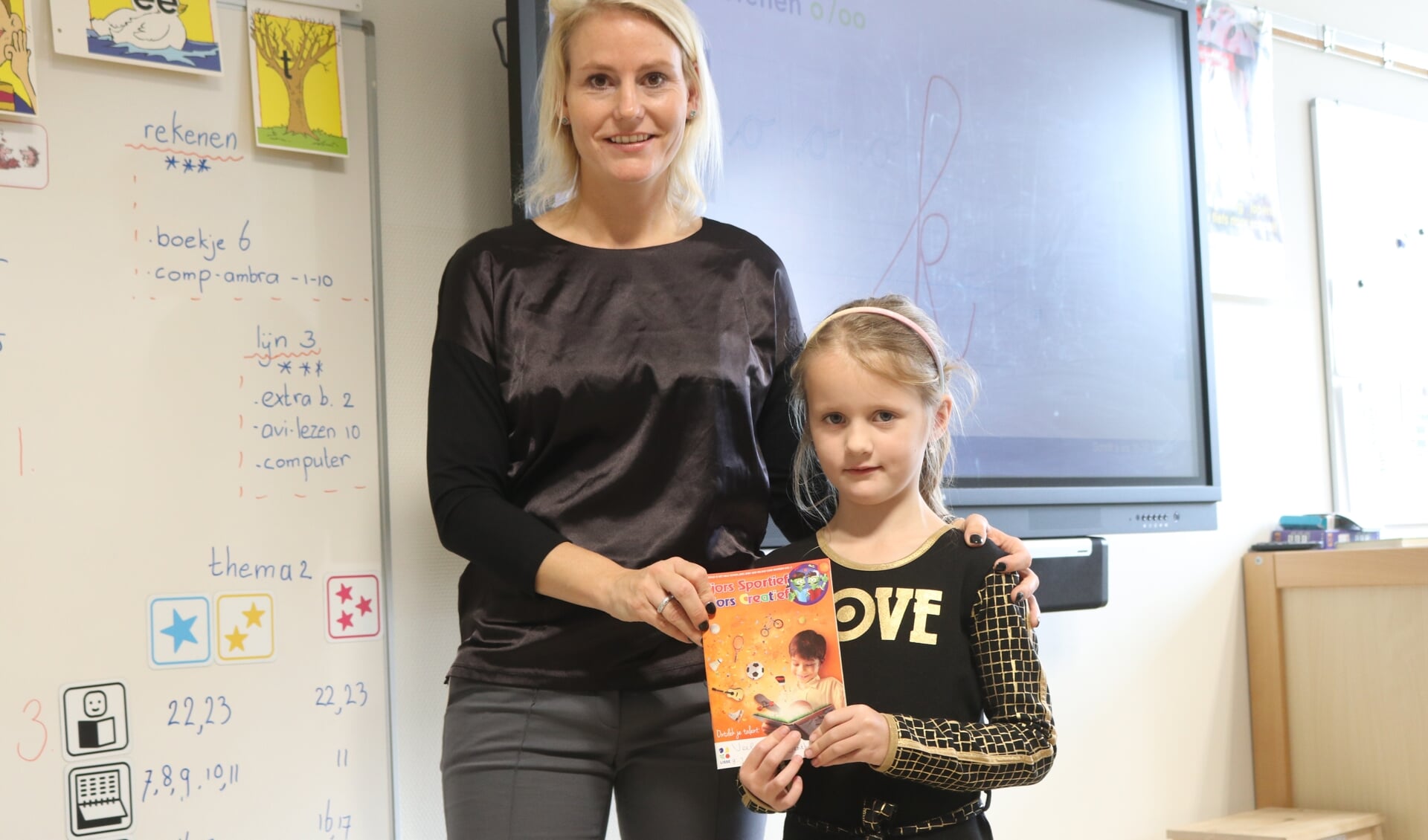 Wethouder Jeanet van der Laan overhandigde bij de Josephschool de eerste boekjes aan leerlingen. | Foto: pr