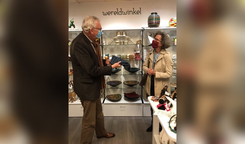 <p>Wethouder Marlies Volten levert in de Wereldwinkel een oude spijkerbroek in. </p>