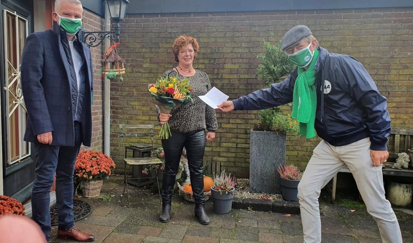 Wethouder Daan Binnendijk en raadslid Huibrecht Bos verrasten Annemiek de Groot met een bloemetje en bedankkaart.