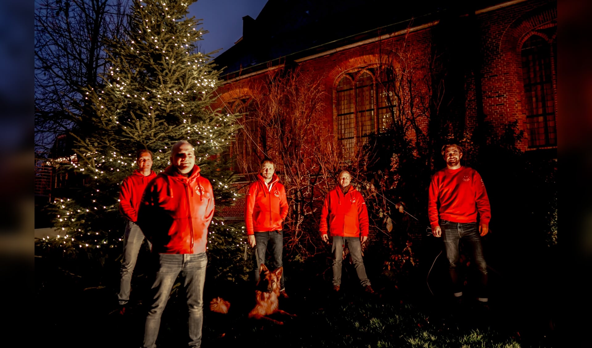 Voorzitter Herbert Zilverentant (linksvooraan) en vier bestuursleden van de Vrienden van het Oude Dorp bij de verlichte kerstboom. 