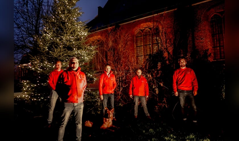 <p>Voorzitter Herbert Zilverentant (linksvooraan) en vier bestuursleden van de Vrienden van het Oude Dorp bij de verlichte kerstboom.&nbsp;</p>  