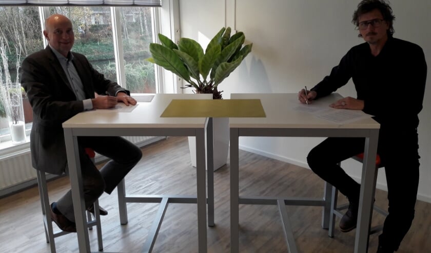 Wethouder Arno van Kempen en voorzitter Rob Batenburg ondertekenen de overeenkomst voor samenwerking tussen gemeente en Sportraad.