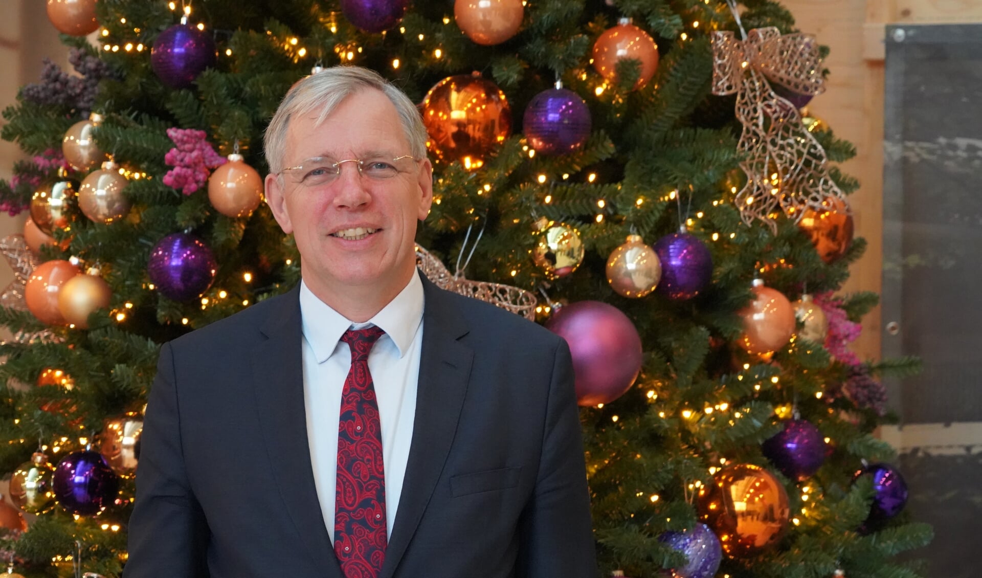 Burgemeester Visser voor de Kerstboom in het stille gemeentehuis. | Foto: Marc Wonnink