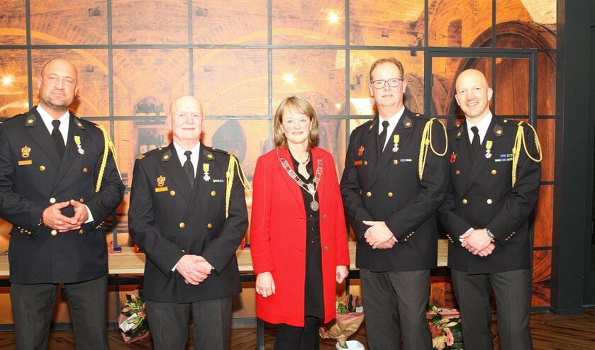 Burgemeester Spruit te midden van de vier Leden in de Orde van Oranje Nassau.
