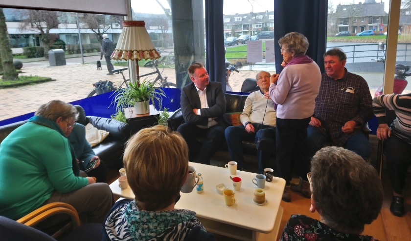 Rik van Woudenberg (geheel links op de bank) in gesprek met de bezoekers van 't Buurthuis.