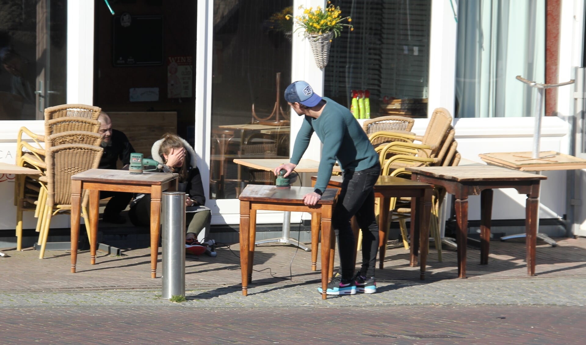 Personeel van De Rosser schuurt de terrastafels in afwachting van beter tijden. | Foto en tekst: Wim Siemerink