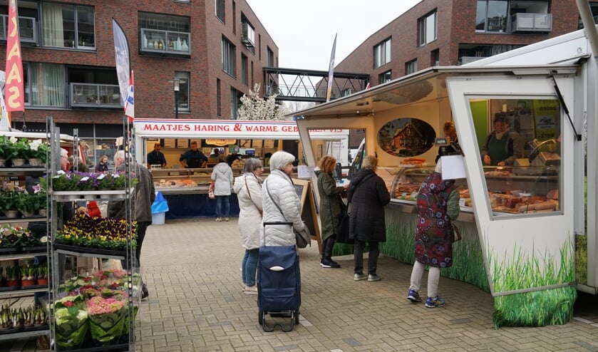 Wachtende klanten van de kaaskraam blijven op ruime afstand van elkaar.