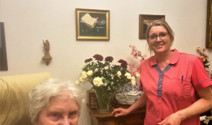 Verzorgende Christien en mevrouw Van Vliet-Kempers (94 jaar), die geniet van de mooie bos bloemen.