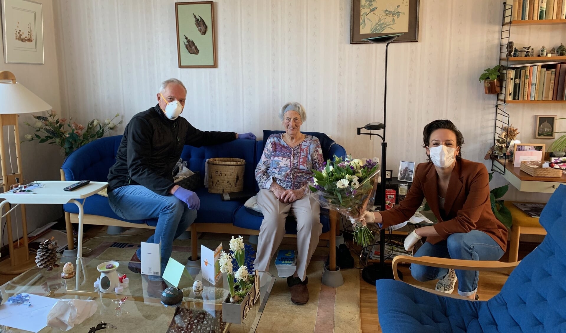 Huisartsen Roel Blanken (l) en Chris Mos (r) feliciteren de 100-jarige mevrouw Van Kampen.