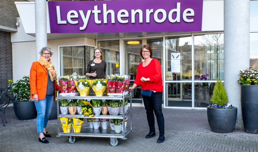 V.l.n.r. Rina Cooijmans van de Oranjevereniging Leiderdorp en Anja van Rijn en Marlèn Bohemen van het Uitbureau van Leythenrode bij de kar vol kleurige planten.