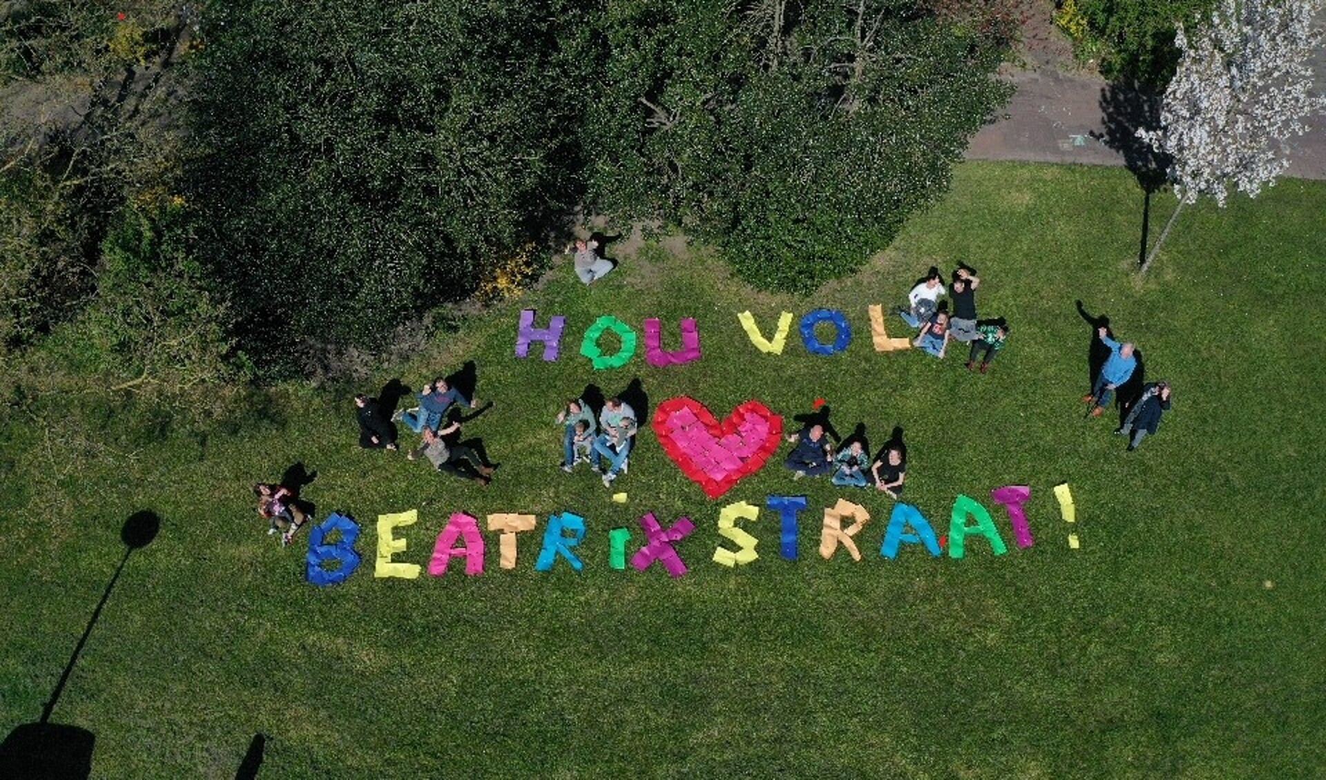Bewoners van de Beatrixstraat steken hun dorpsgenoten een hart onder de riem met een kunstig van kleurig papier gemaakte boodschap.