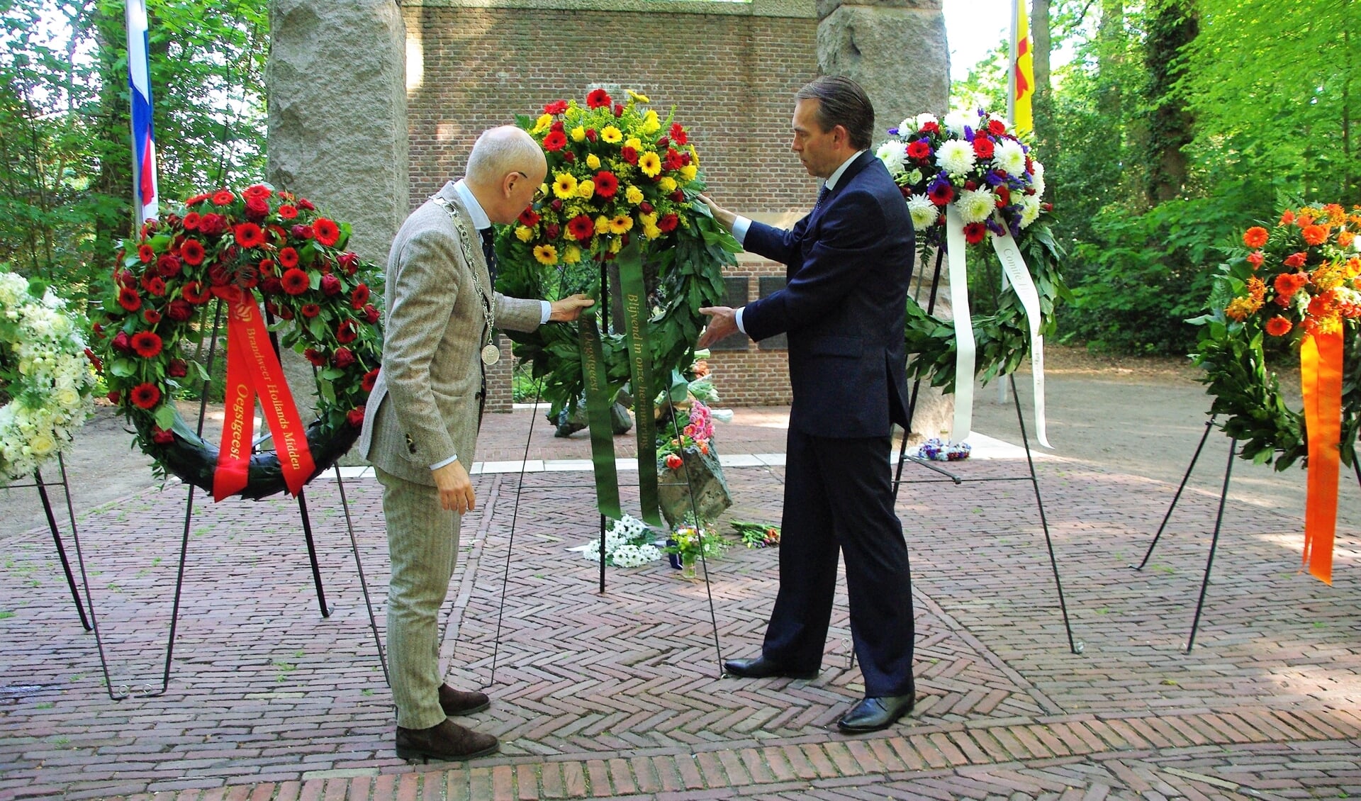 Burgemeester Emile Jaensch plaatst met Eelke van den Ouweelen, nestor van de gemeenteraad, een krans bij het monument. 