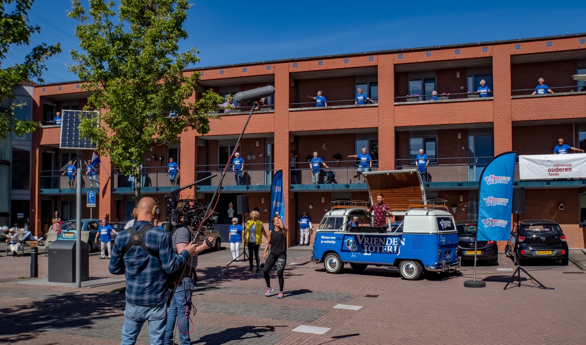 De cameraploeg van SBS Shownieuws filmt het balkonbewegen aan de Brandwacht. In het busje van de Vriendenloterij volgt Jan Versteegh het voorbeeld van Nathalie Beekman (in zwart shirt). Burgemeester Driessen (met geel jasje) staat links van Nathalie. 