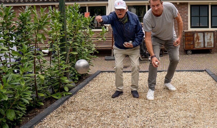 Frans Brocken gooit een oefenbal, Bob Meijer staat klaar om zijn bal te werpen.