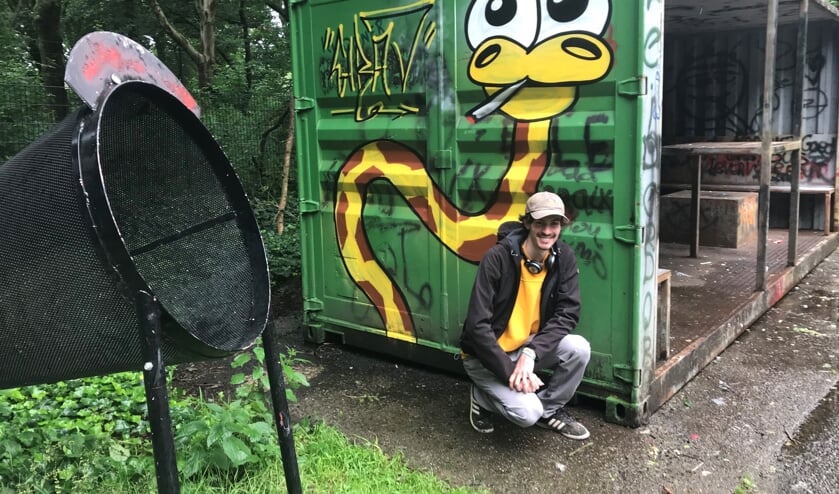 Dennis Bonsen, in de graffiti scène ook bekend als Girav, poseert bij zijn kunstwerk in de Bloemerd.