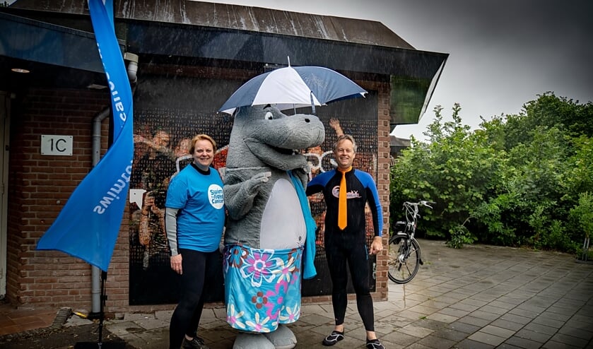 Wethouder Willem Joosten en project manager van Swim to Fight Cancer Leiderdorp Claudia Hoogmoed samen met zwemmascotte Jip, vlak voor ze de Dwarswatering in gaan. | Foto: J.P. Kranenburg