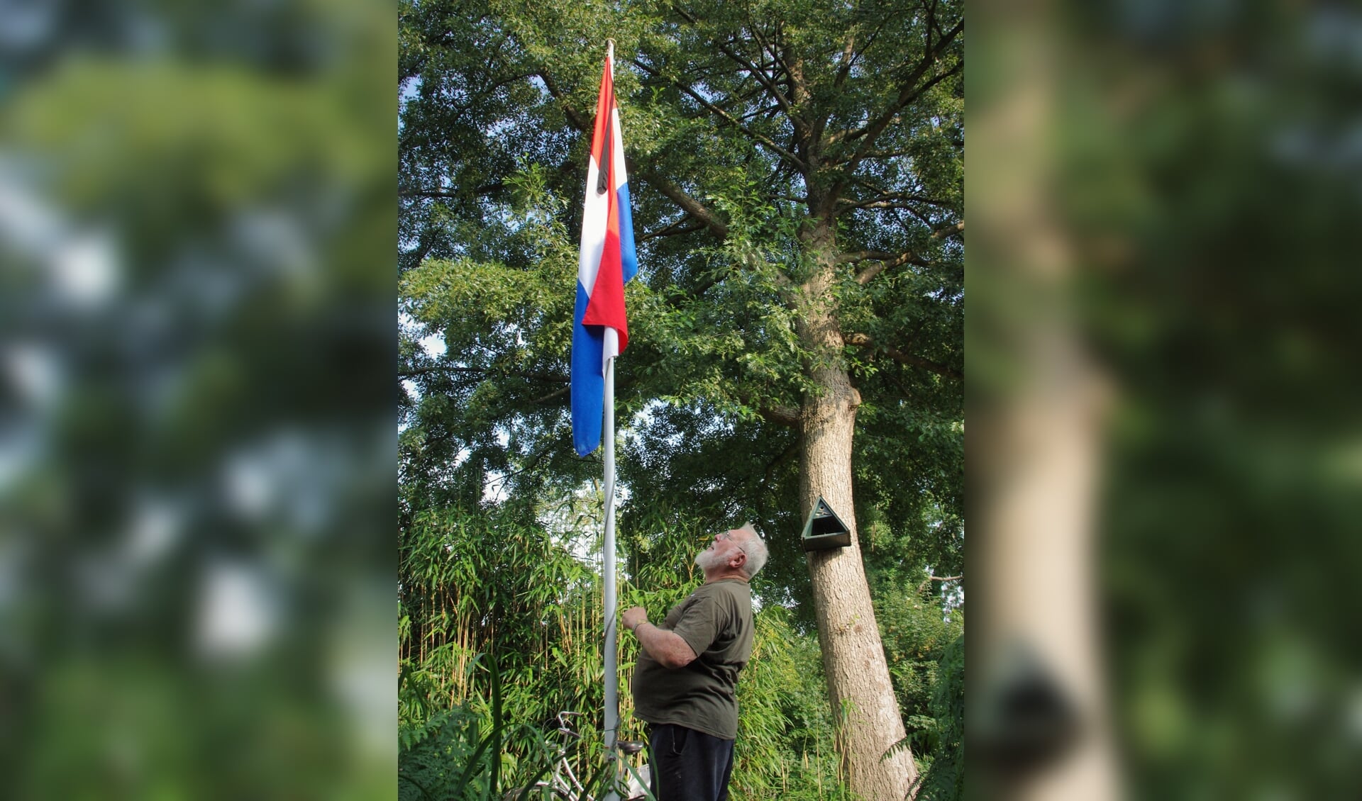 Dirk Megchelse bij zijn vlag met zwarte wimpel in de voortuin. | Foto Willemien Timmers