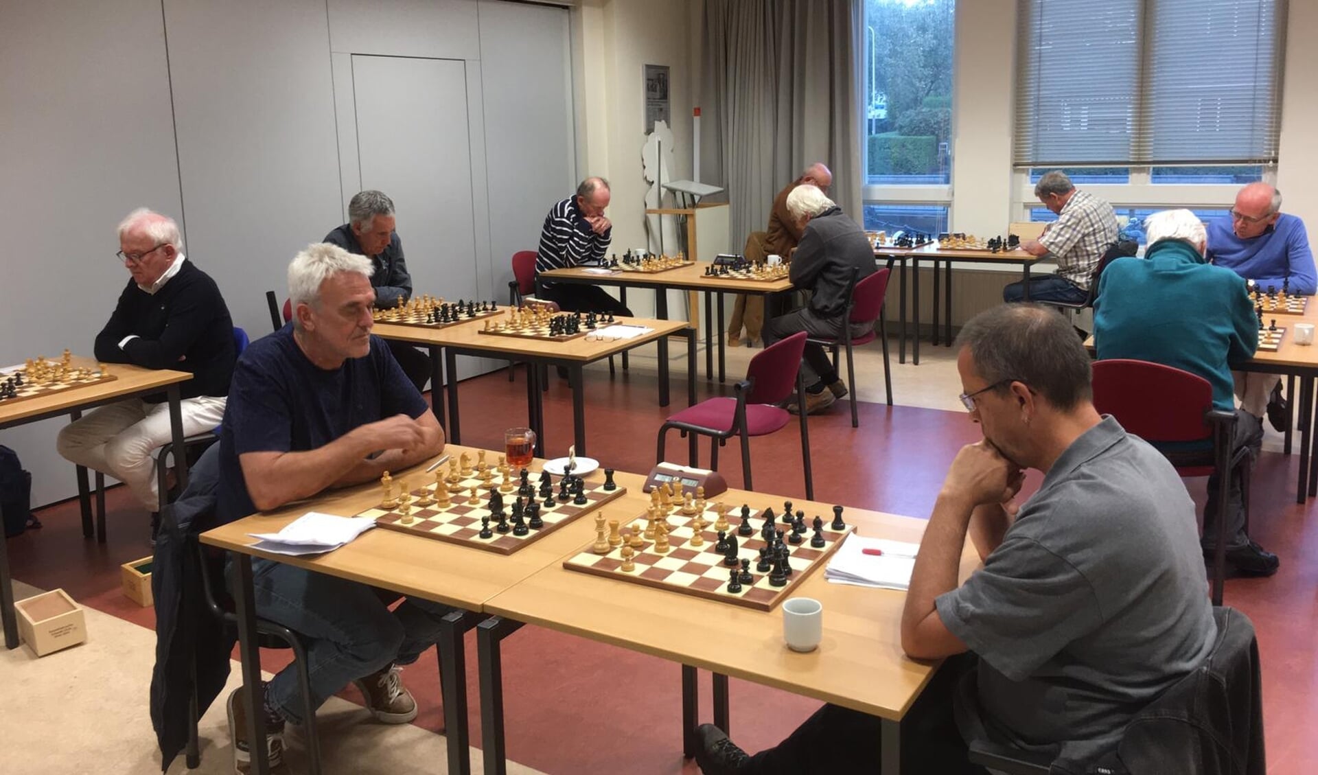 De schakers van de Sassenheimse Schaakverenigingen schaken op anderhalve meter van elkaar. Tijdens de wedstrijd hebben ze ieder een eigen bord. | Foto: pr.