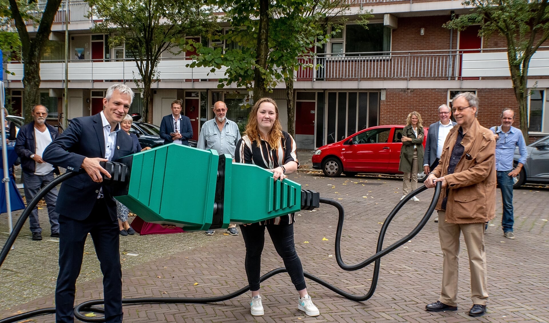 Gedeputeerde Berend Potjer (GroenLinks) verricht samen met bewoners Mariëlle van Gijzen en Egbert Boonstra de openingshandeling voor de  zonnestroominstallatie aan de Langedijkdreef.