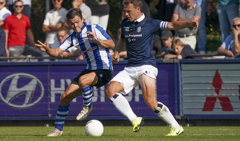 Nick Runderkamp probeert Peet van der Slot van Koninklijke HFC de bal af te spelen. | Foto: OrangePictures