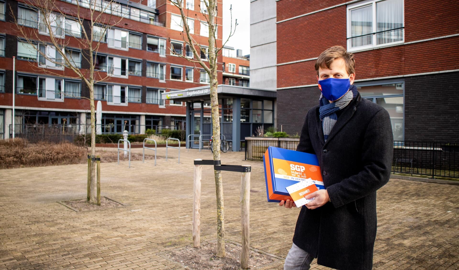 Geert Schipaanboord met een doos stroopwafels bij De Ommedijk.