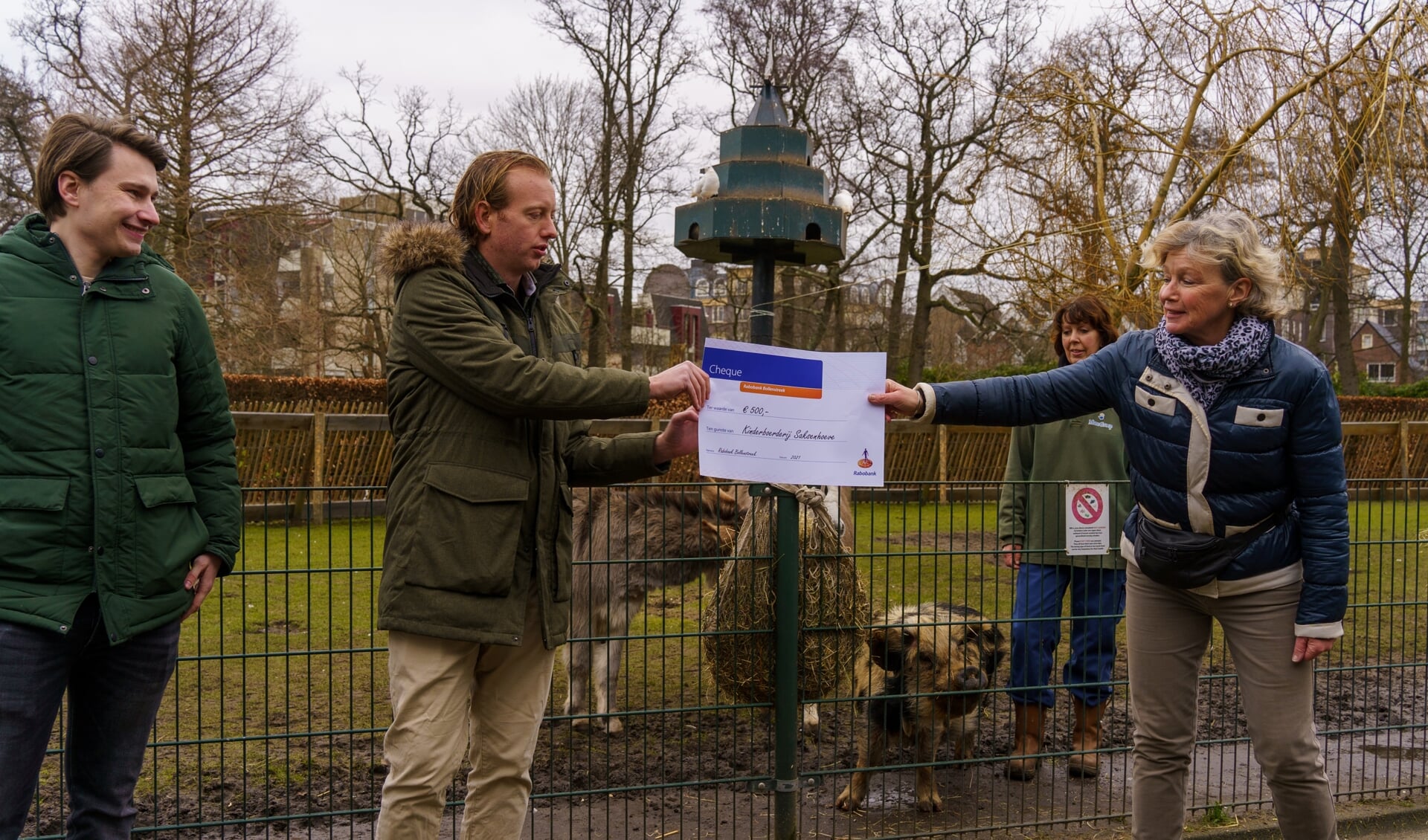 Tjalling Ciggaar overhandigt op veilige afstand de cheque van 500 euro aan Saskia ten Velden, leidinggevende bij de kinderboerderij in Park Rusthoff. | Foto: pr./Kees Guldemond