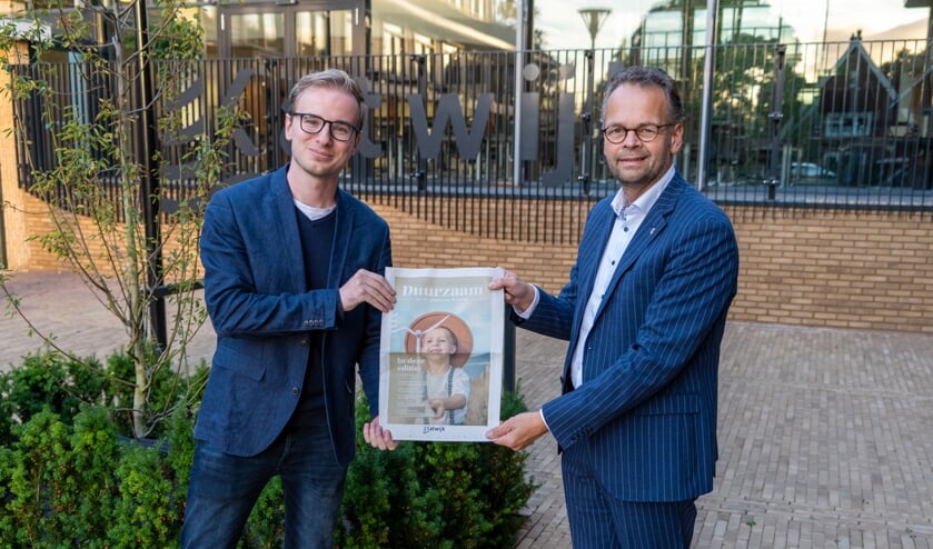 <p>Wethouder Jacco Knape(re) toont samen met beleidsmedewerker Steven van der Plas de Duurzaamheidskrant. </p>