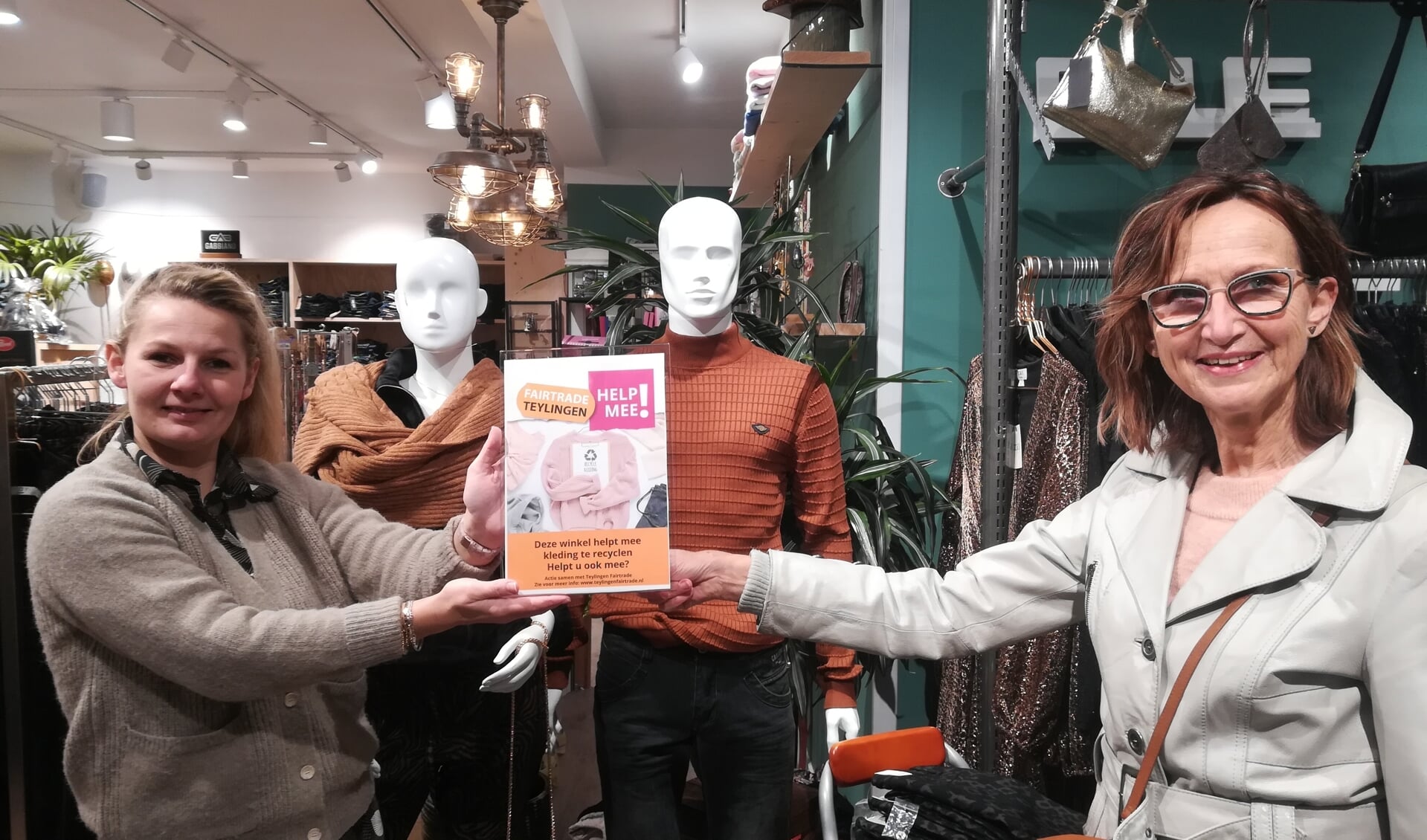 Monique Knops van Teylingen Fairtrade overhandigt Wendy van Kampen van de Sassenheimse kledingwinkel Blue-In het winkeldisplay, als aftrap voor de kleding recycle actie. | Foto: pr.