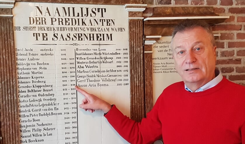 SOS Werkgroepvoorzitter Genealogie Aad Lelijveld bij het predikantenbord (1886) met daarop ds. Cloppenburg. | Foto: pr.