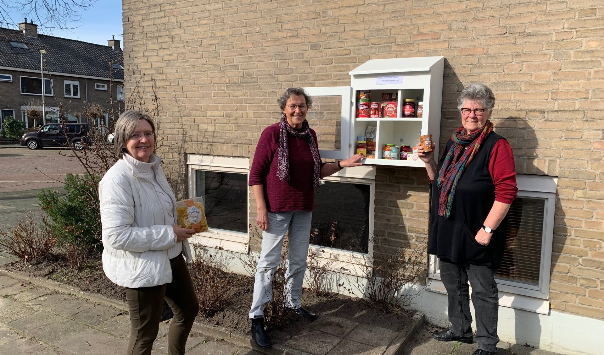 V.l.n.r. Heleen Feenstra, Marijke van Pernis en Ellis Groothoff bij het buurtkastje aan het Burchtpad.