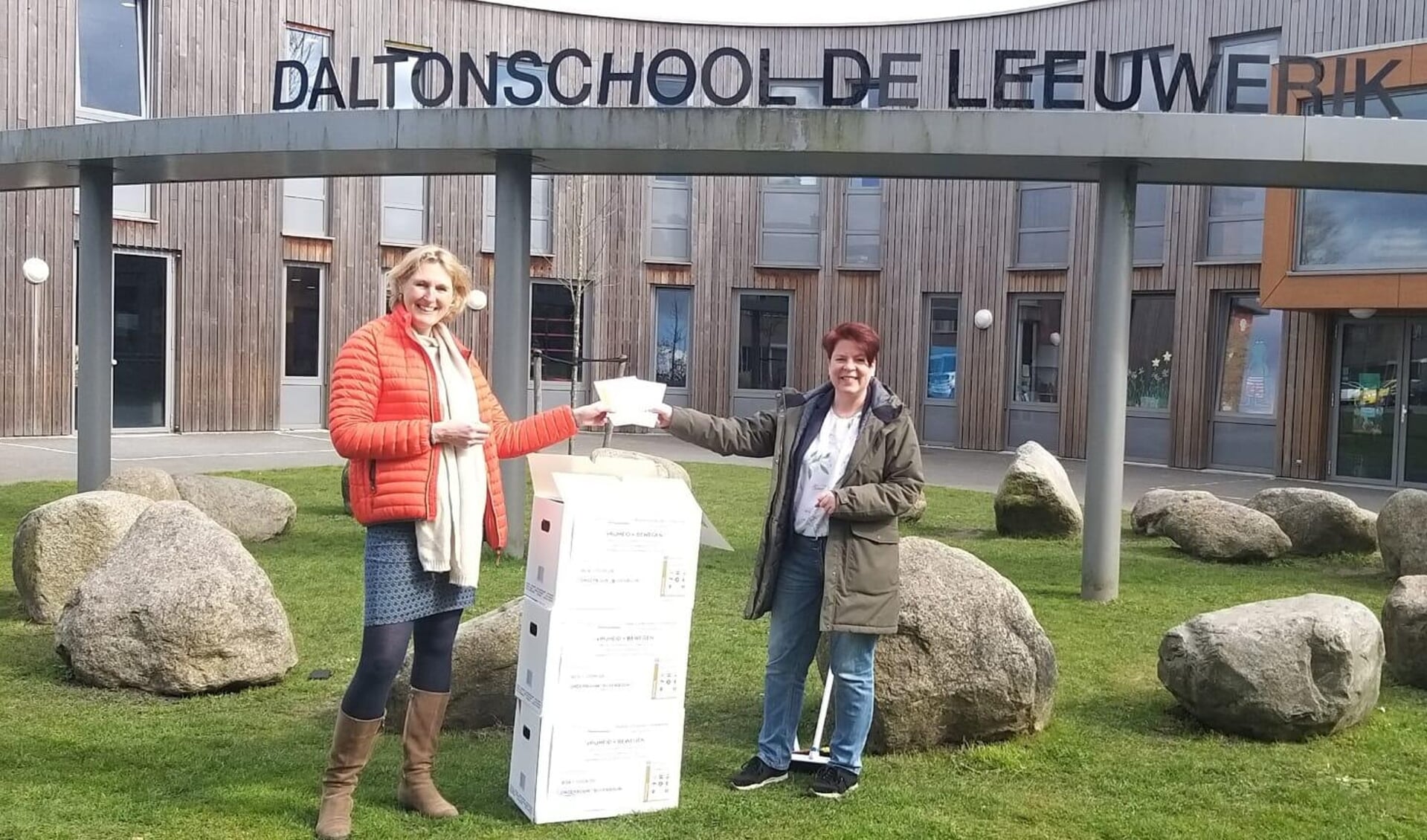 Esther Baars (links) van de Oranjevereniging Leiderdorp overhandigde de Vrijheidsboxen aan Marian Soullié van basisschool De Leeuwerik. 