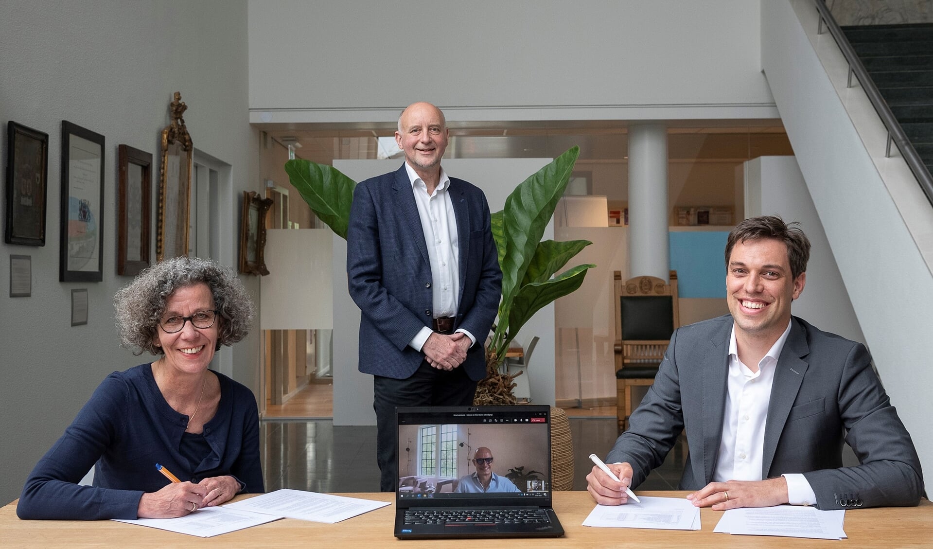Wethouders Marlies Volten en Arno van Kempen (staand) ondertekenen de overeenkomst met ontwikkelmanager Stefan van Vliet (rechts). Ontwikkelaar Ewoud Swaak is digitaal aanwezig. | Foto: pr.