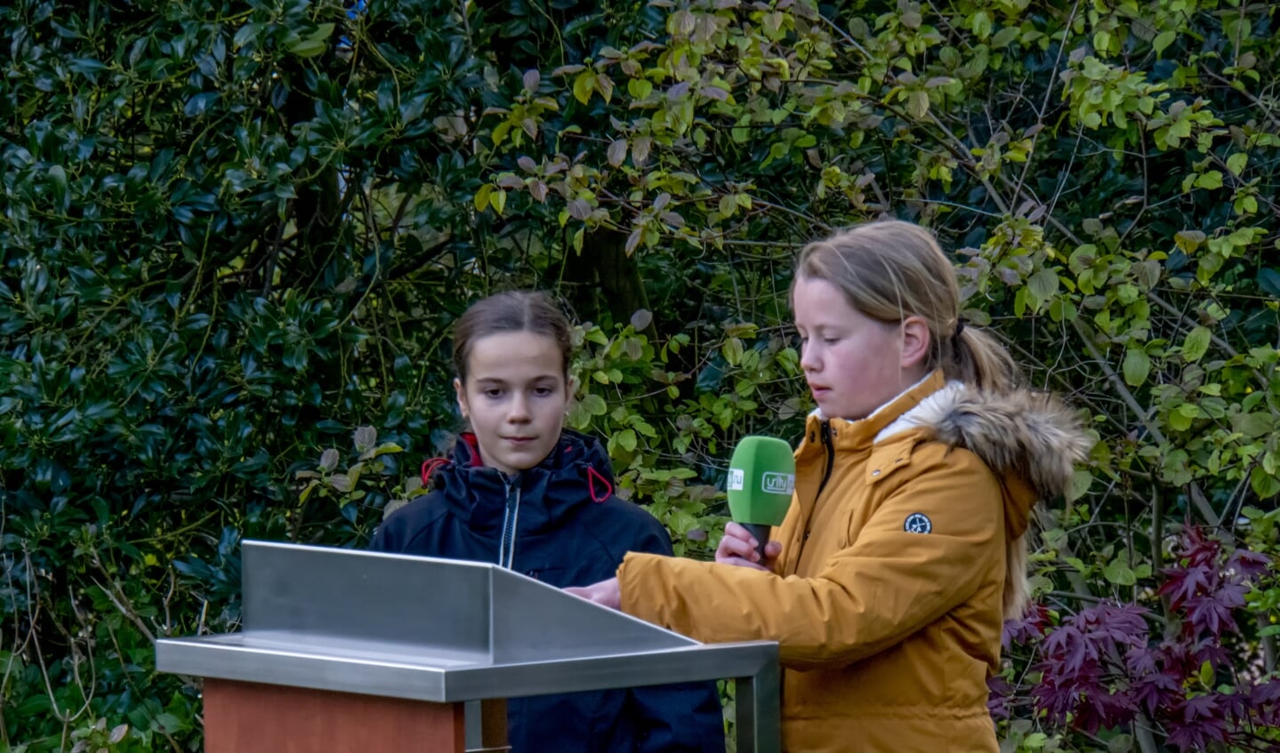 Julia leest haar gedicht voor, naast haar staat Frederique. 