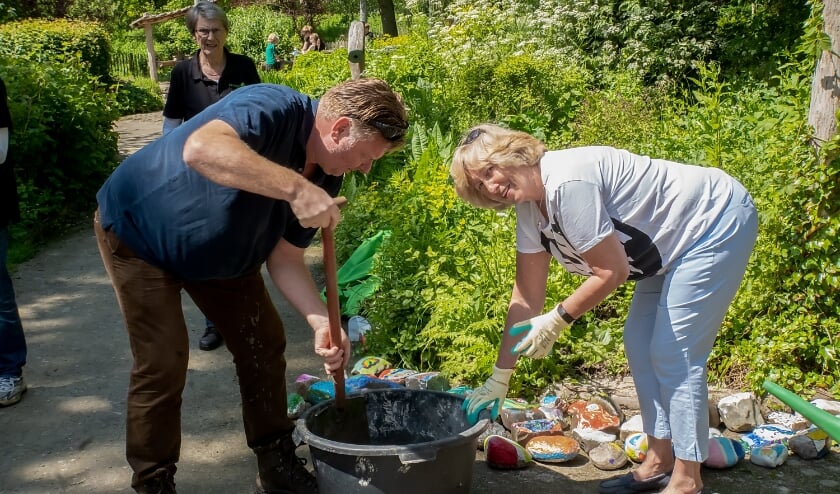 <p>Burgemeester Laila Driessen en wethouder Rik van Woudenberg plaatsten kleurrijke stenen langs het Verwonderpad. Op de achtergrond voorzitter Riny Vons van de Stichting Natuurspeeltuin Leiderdorp </p>