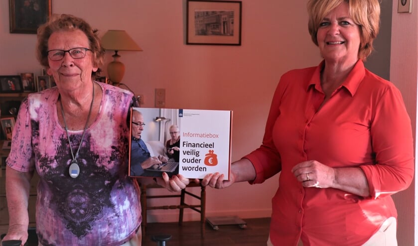 <p>Rabobankmedewerker Ivette van Houdt overhandigt de informatiebox 'Financieel veilig ouder worden' aan een inwoner van een zorginstelling. </p>