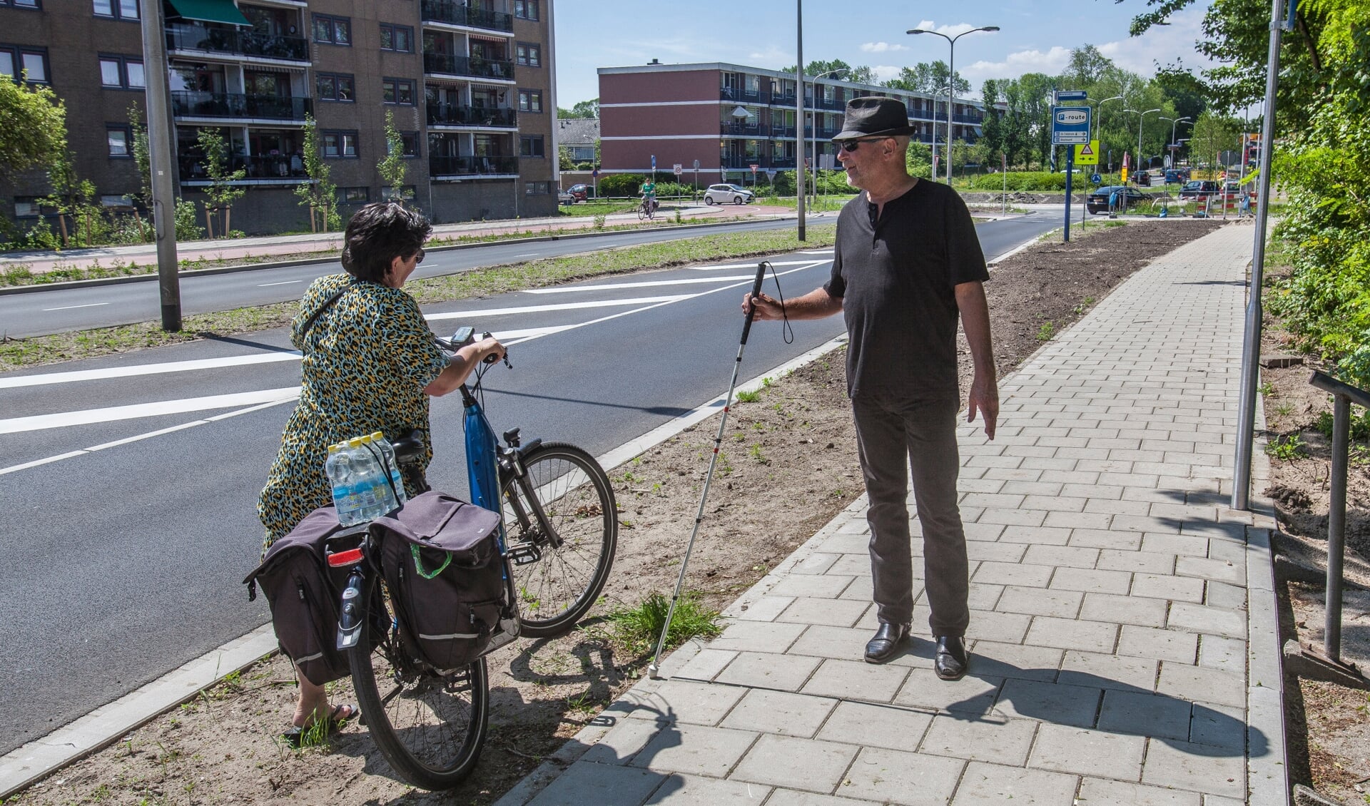 Koos Ouwehand spreekt een fietsster aan die over het voetpad rijdt. | Foto: Adrie van Duijvenvoorde