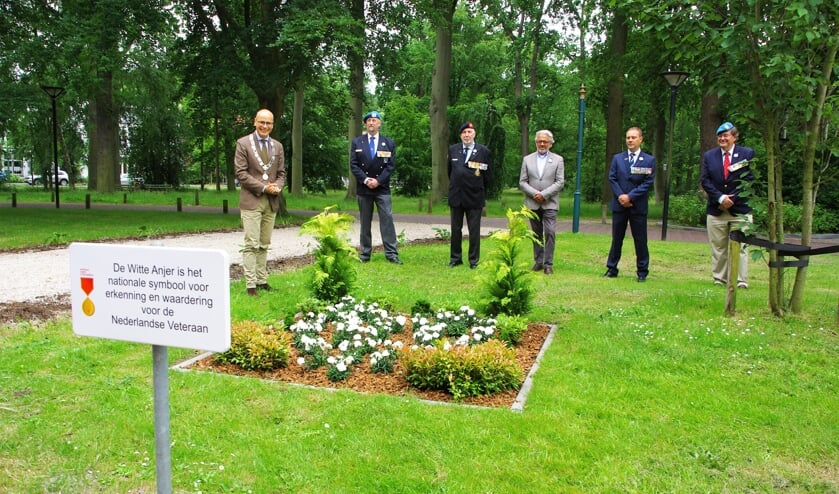 <p>Een feestelijk moment: Emile Jaensch, Bert Hermans, Willem van den Houten, Joop Verdonk, Eric Lentz en Lodewijk Grooters bij het Witte Anjerperkje in de voortuin van het gemeentehuis. | Foto Willemien Timmers</p>