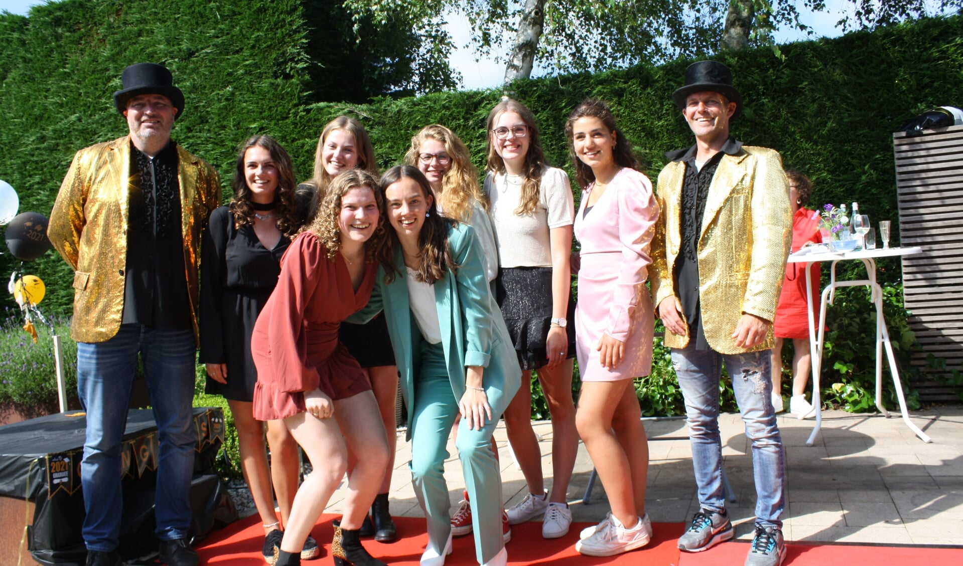 Met vriendinnen en klasgenoten gaan de vier meiden en hun mentoren op de foto. Van links naar rechts: Roos, Pien, Roza, Babs, Evelien, Rolieke en Maaike.