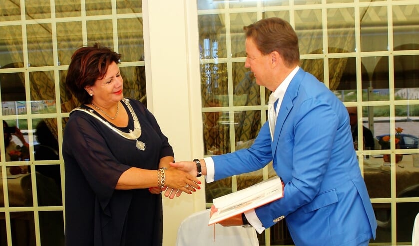 <p>Bram Mol overhandigt het eerste exemplaar van het promotieboek aan Burgemeester Verkleij. </p>