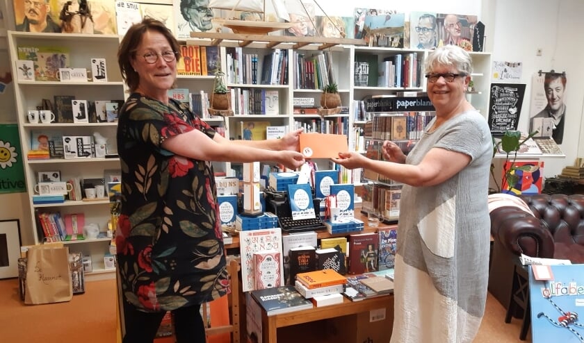 Sanne Boswinkel (links) ontvangt de boekenbon uit handen van Cadja van Rooden.