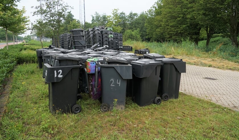 Honderden ingezamelde grijze bakken wachten op de parkeerplaats bij het gemeentehuis op afvoer naar de shredder.