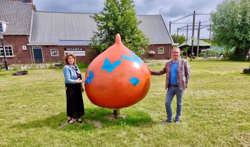 <p>Kunstenares Anita van Diemen en wethouder Jan van Rijn bij een van de twee reuzenbollen die in Hillegom staan. | Foto: Annemiek Cornelissen.</p>