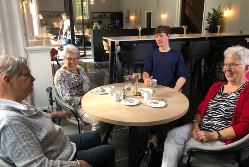 <p>Zonnebloemgasten in gesprek met student Yannick, vrijwilliger social media.</p>