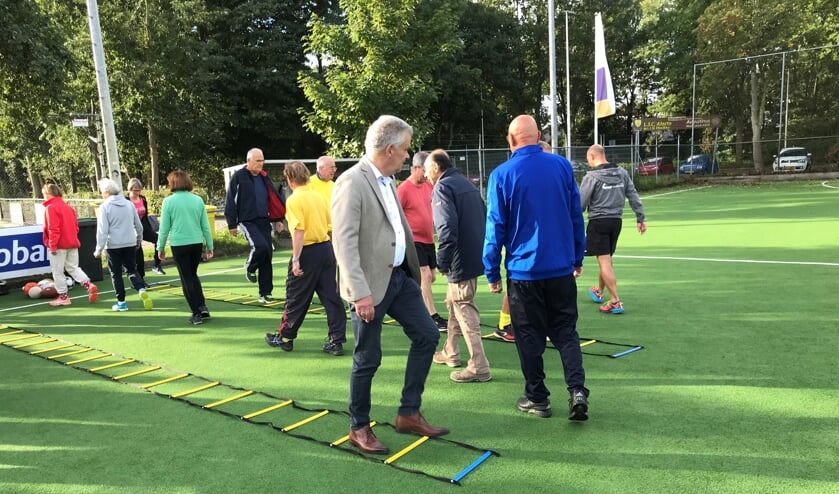 Wethouder Binnendijk doet mee aan de warming-up van Clubhuis De Derde Helft